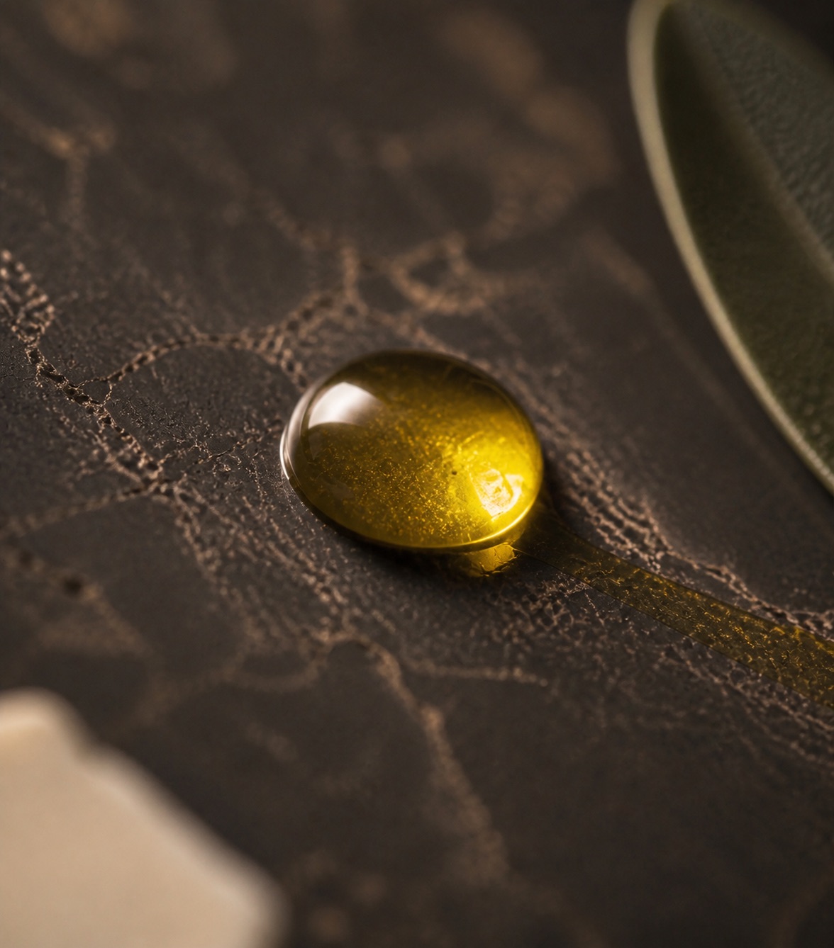 A bead of unfiltered oil on dark stone